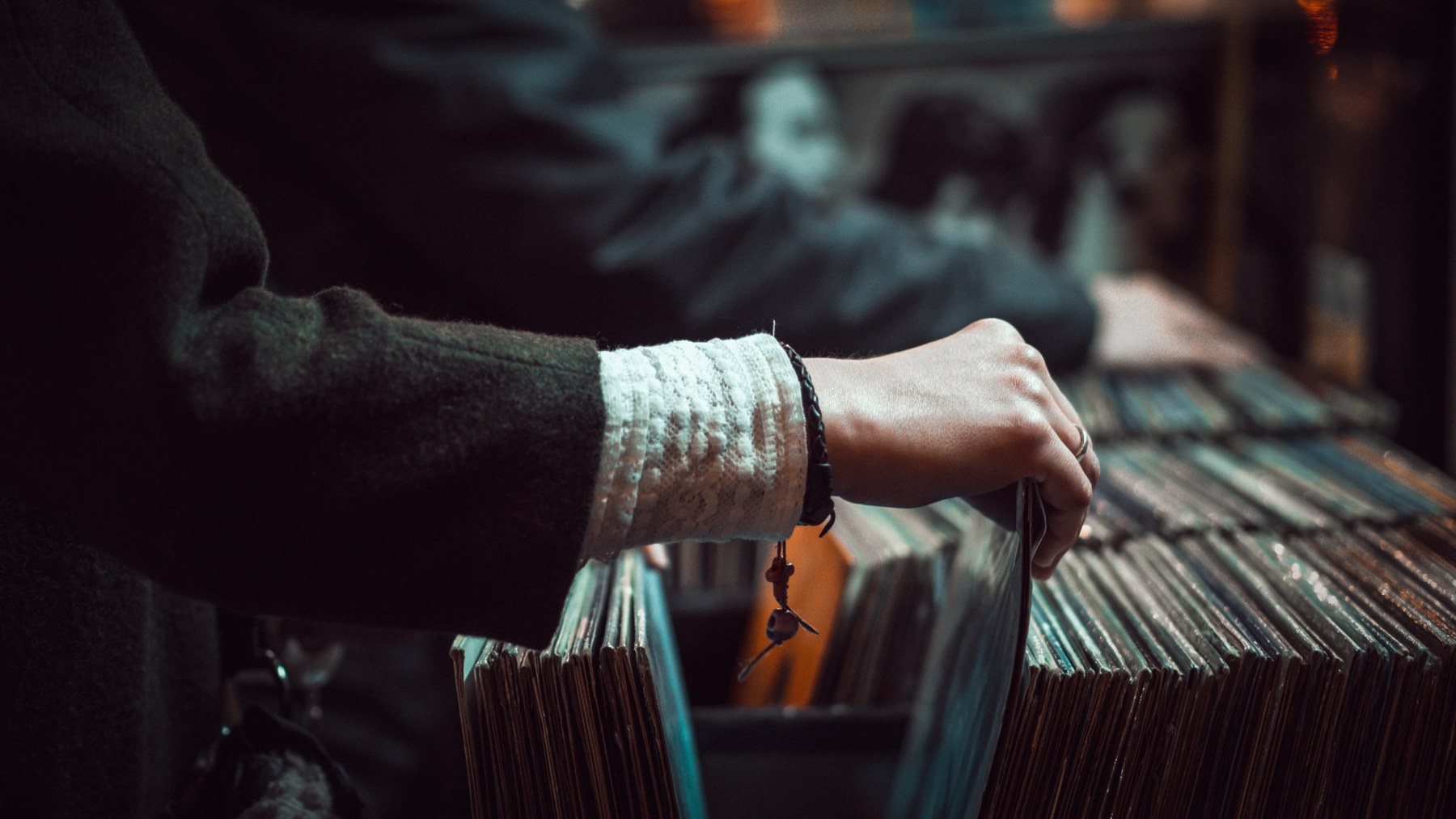 A shopper browses rows of vinyl records in a record store