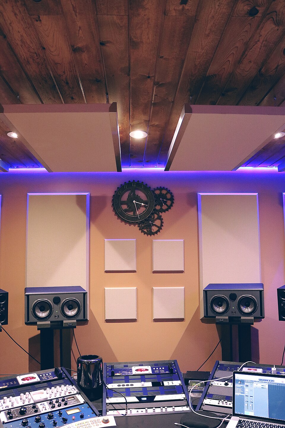 A recording studio with monitor speakers, acoustic treatment and a computer workstation
